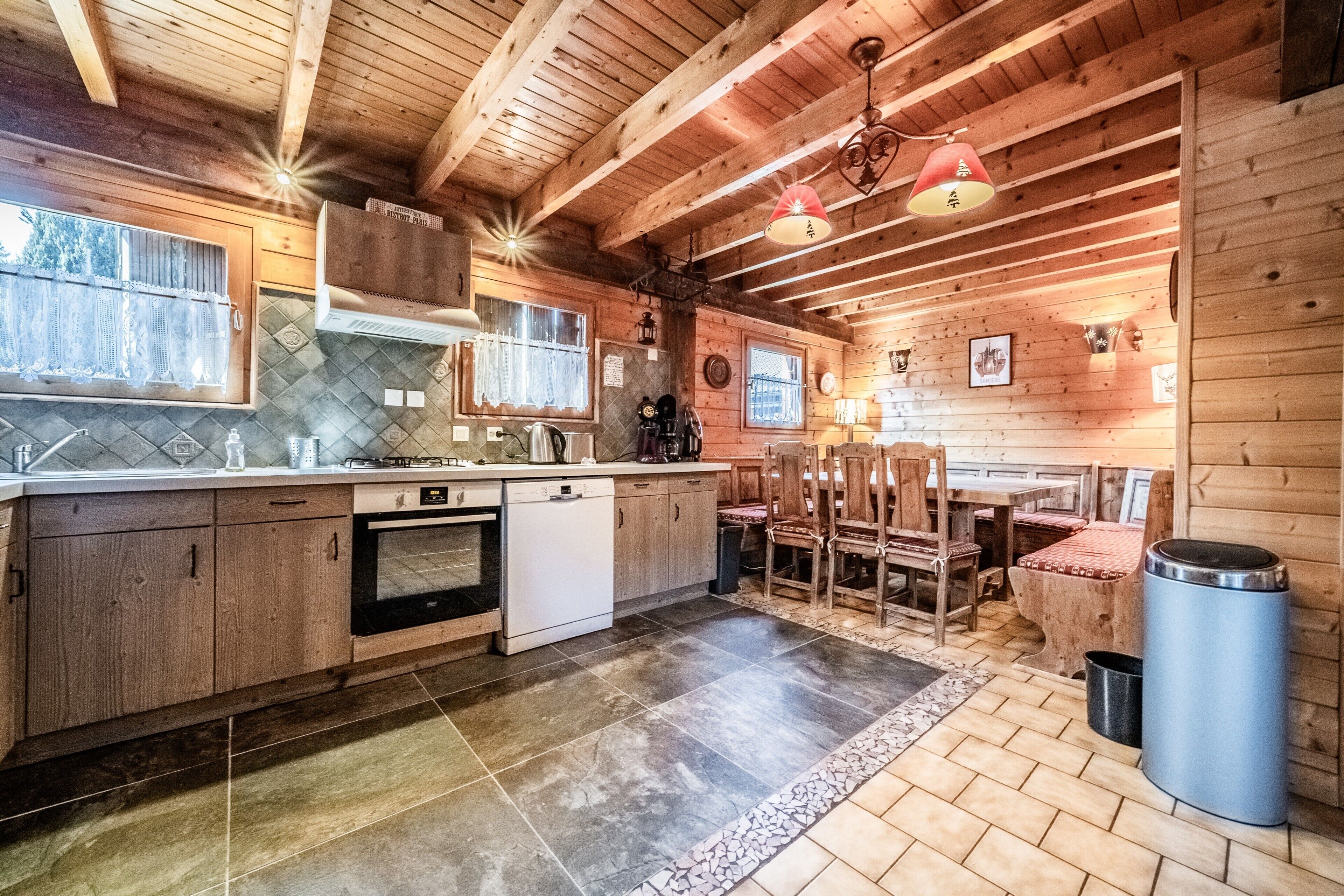 Ambiente interno in legno con cucina, zona pranzo e un cestino.