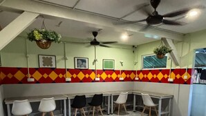 A conference room with a tiled floor, several tables, and chairs. - OYO 91278 5minutes Lodge (Kota Kinabalu)
