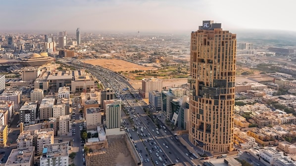 A cityscape with a prominent high-rise building, a busy highway, and surrounding urban infrastructure.