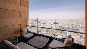Un balcone con mobili in vimini e vista sulla città.