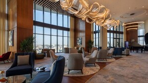 Un'ampia hall con arredi moderni, ampie finestre e un originale lampadario.