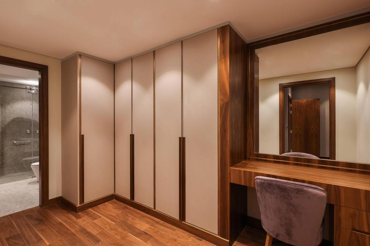 A modern bathroom with a wooden vanity, a mirror, and a shower area.
