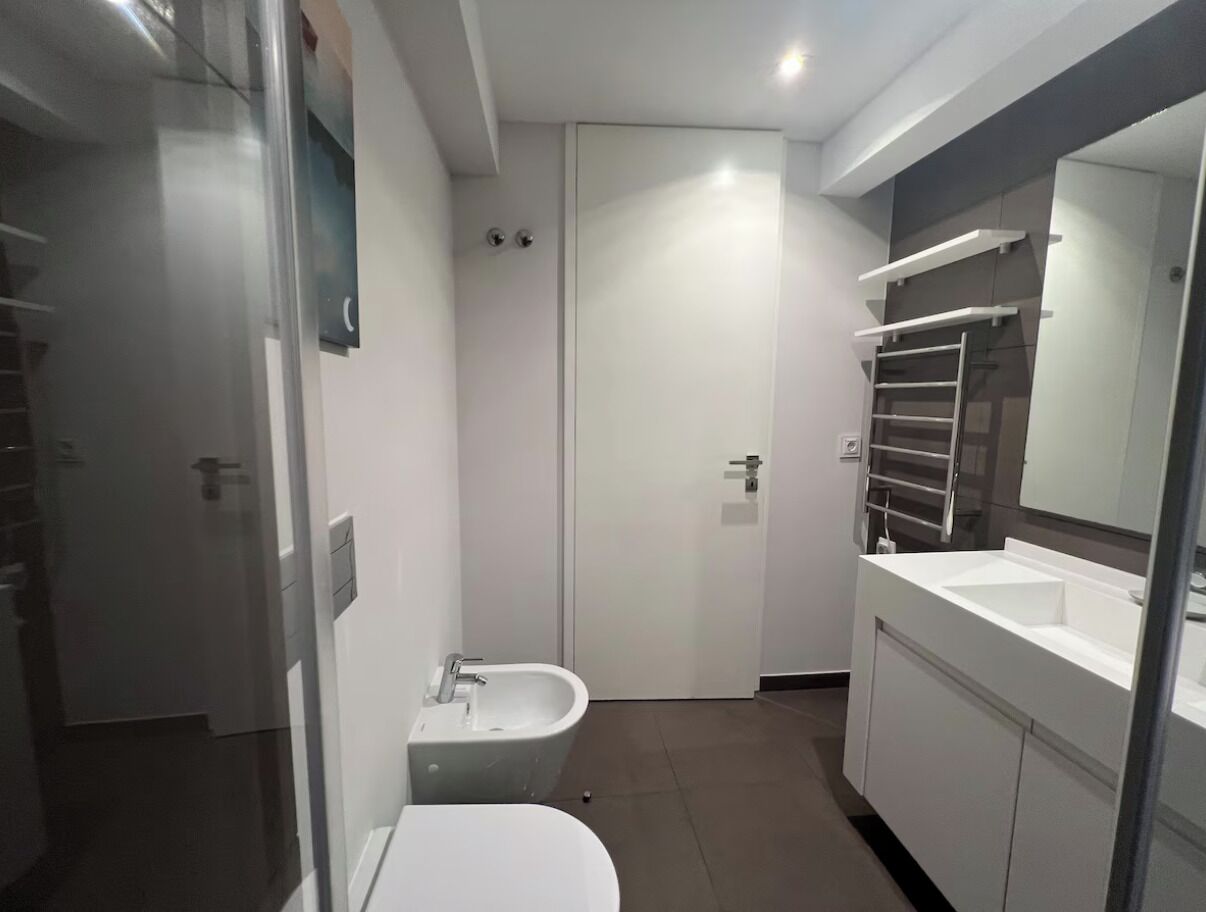 A modern bathroom with a bathtub, toilet, and sink.
