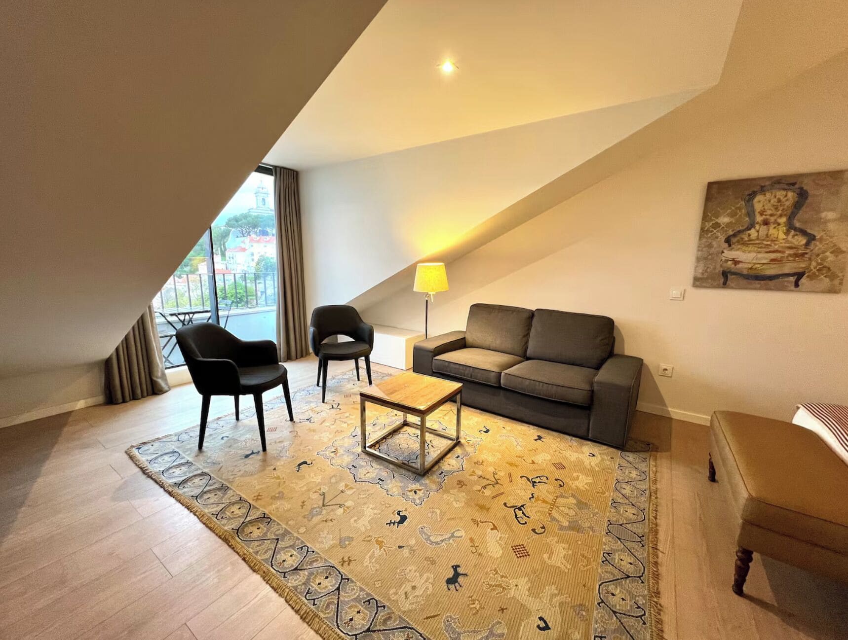 Un salon moderne comprenant un canapé, deux fauteuils, une table basse et un tapis.