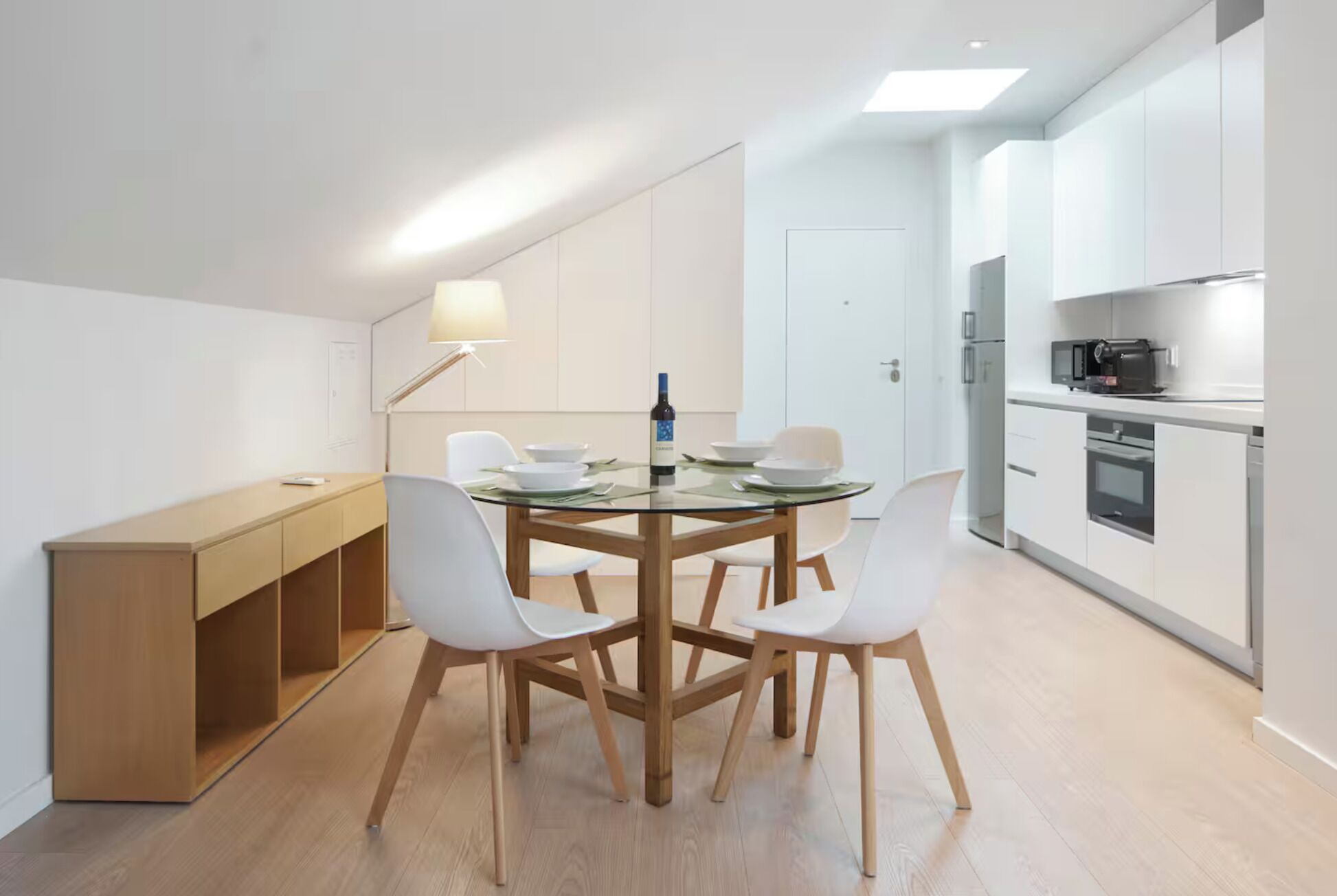 A modern kitchen with white cabinets, a built-in oven, and a microwave.