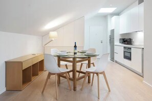 A modern kitchen with white cabinets, a built-in oven, and a microwave. - Amazing View in Castle View (Lisbon)