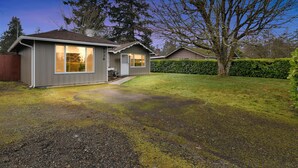 A single-story house with a front porch, a garage, and a well-maintained lawn. - Hoops & Hygge Private Sport Court Retreat 3 Bedroom Home (Lakewood)