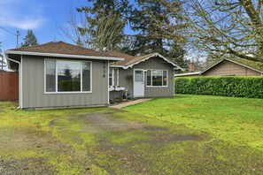A single-story house with a grey exterior, a front porch, and a well-maintained lawn. - Hoops & Hygge Private Sport Court Retreat 3 Bedroom Home (Lakewood)