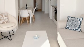 Ein modernes Wohnzimmer mit einer Couch, einem Couchtisch und einem Essbereich mit Stühlen und einem Tisch.