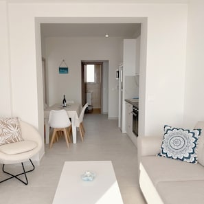 Un salon moderne comprenant un canapé, une table basse et un coin repas avec des chaises et une table.