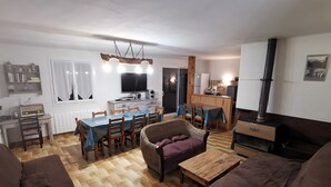 A living room with a sofa, a dining table, and a TV.