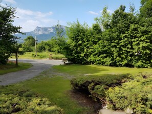 A rural road with a bicycle, lush greenery, and a mountain in the background.