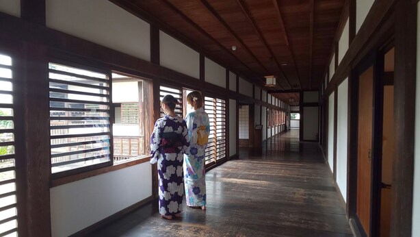 A corridor with wooden beams and tatami mat flooring. - Utility Hotel Cooju (Kawagoe)