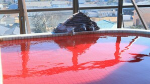 An indoor swimming pool with a red tiled floor and a small brick structure with a faucet. - Seaside Hotel Kujukuri (Sanmu)