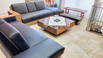 Un salon moderne avec un canapé, une table basse et une petite table en bois.