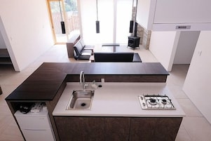 A modern kitchen with a central island, built-in gas stove, and a sink.