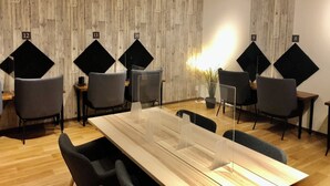 A conference room with a wooden wall, numbered acoustic panels, and modern furniture.