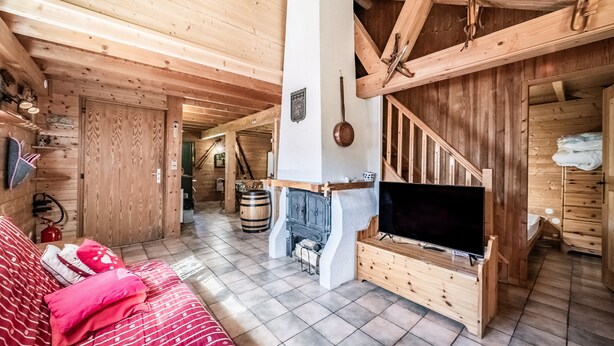A wooden interior with a fireplace, a television, and a sofa. - Chalet “8p Simple - Les Mésanges” with Mountain View, Private Terrace, and Wi-Fi (Verchaix)