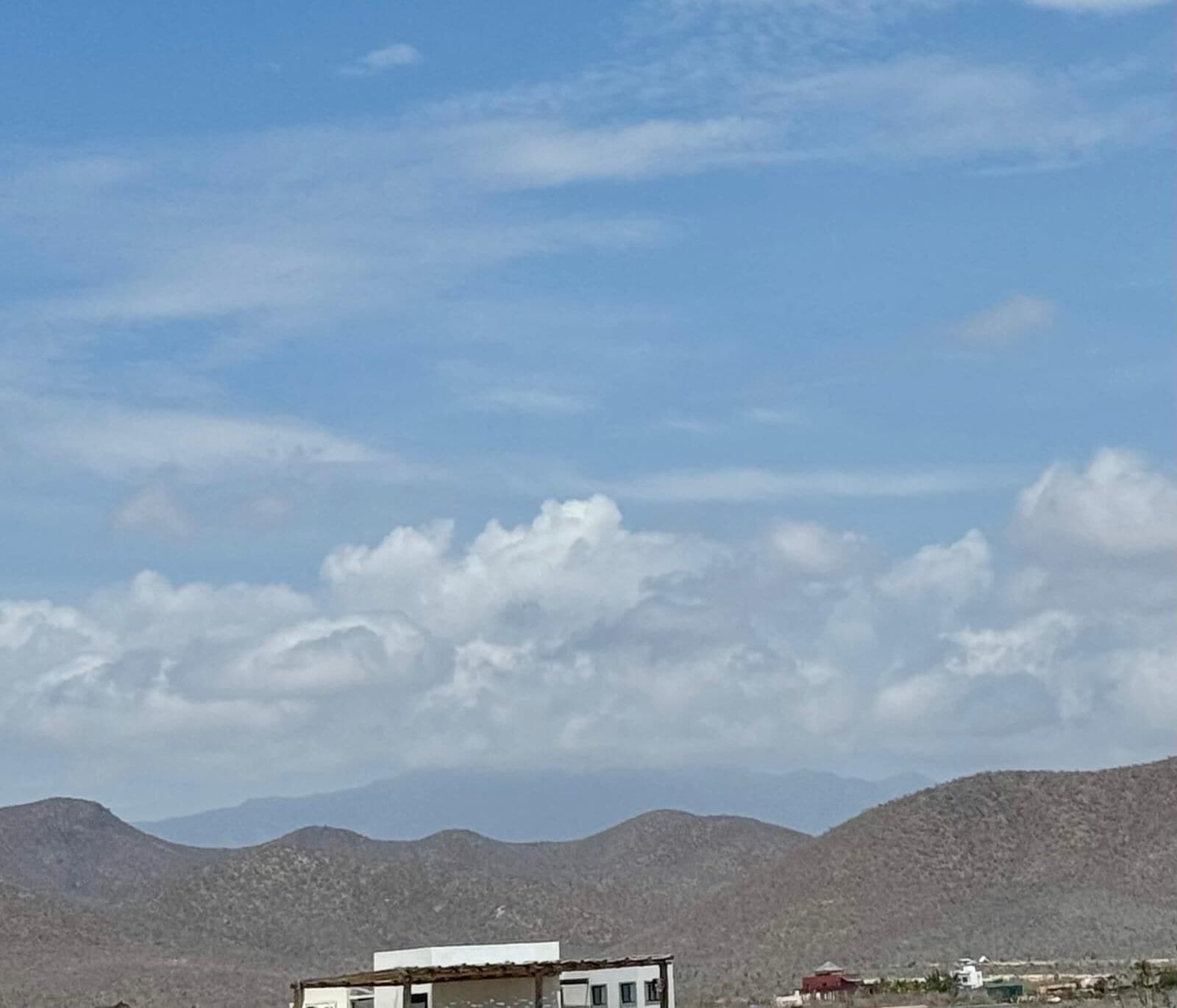A mountainous landscape with a clear sky and a few clouds.