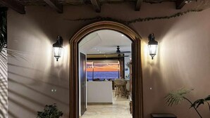 A hallway with a tiled floor leading to a room with a view.