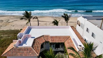 Na praia, areia branca, espreguiçadeiras, guarda-sóis
