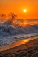 Una playa con olas al atardecer.