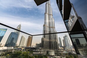 A high-rise building with a sleek, reflective facade, surrounded by other modern skyscrapers. - Elite 2BR Address Opera Burj Khalifa View (Dubai)