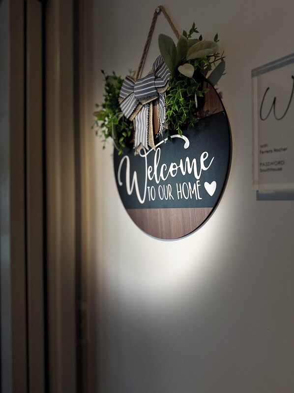A wall-mounted welcome sign with a bow and greenery. - Resort-Style Family Retreat with Pool & Views (Albion Park)