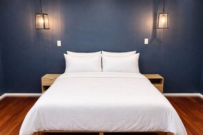 Una camera da letto con un letto, due comodini e due luci a parete.