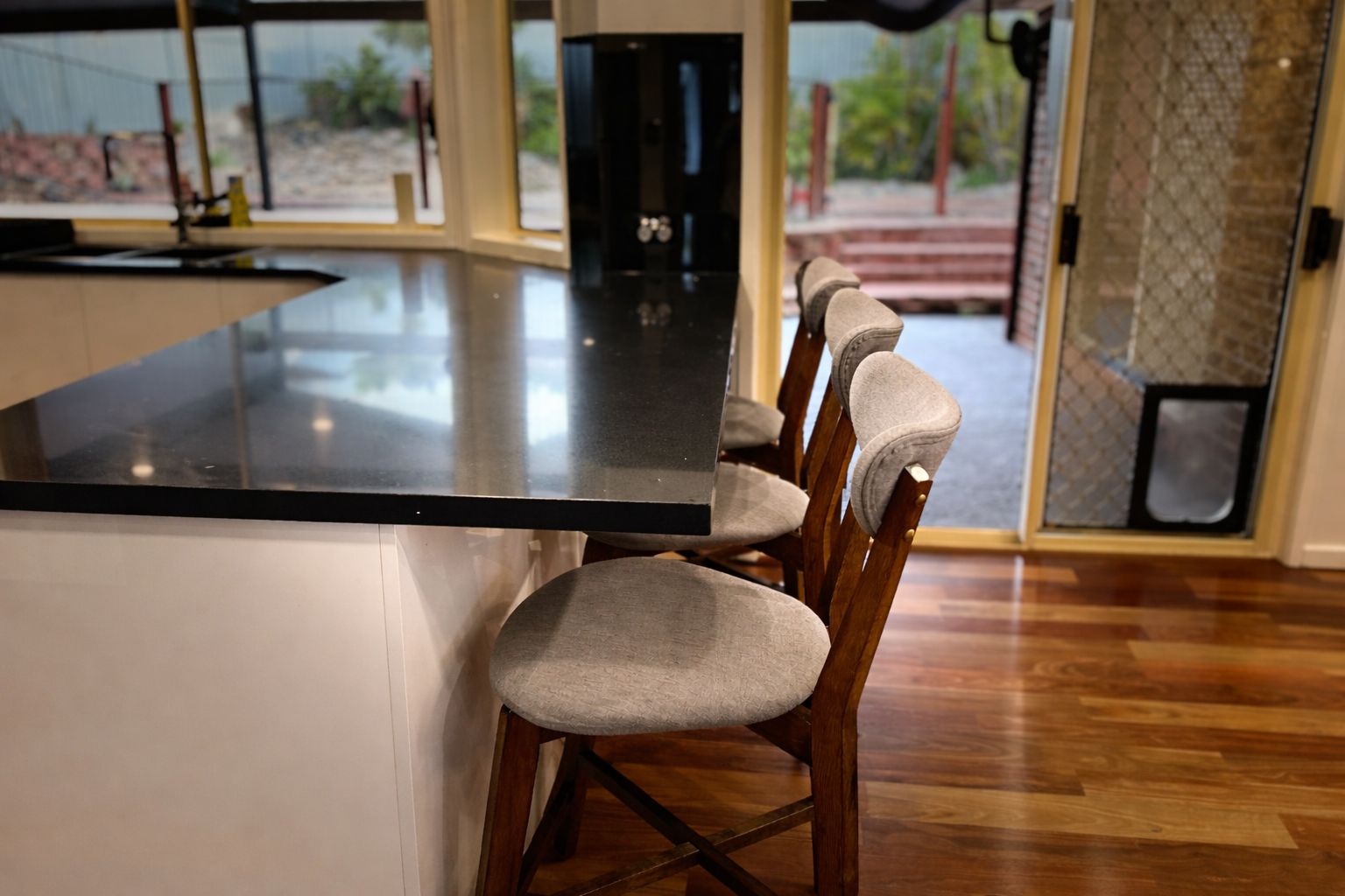 A kitchen with a central island and bar stools.