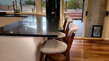 A kitchen with a central island and bar stools.