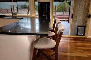 Cuina amb una illa central i tamborets de bar.