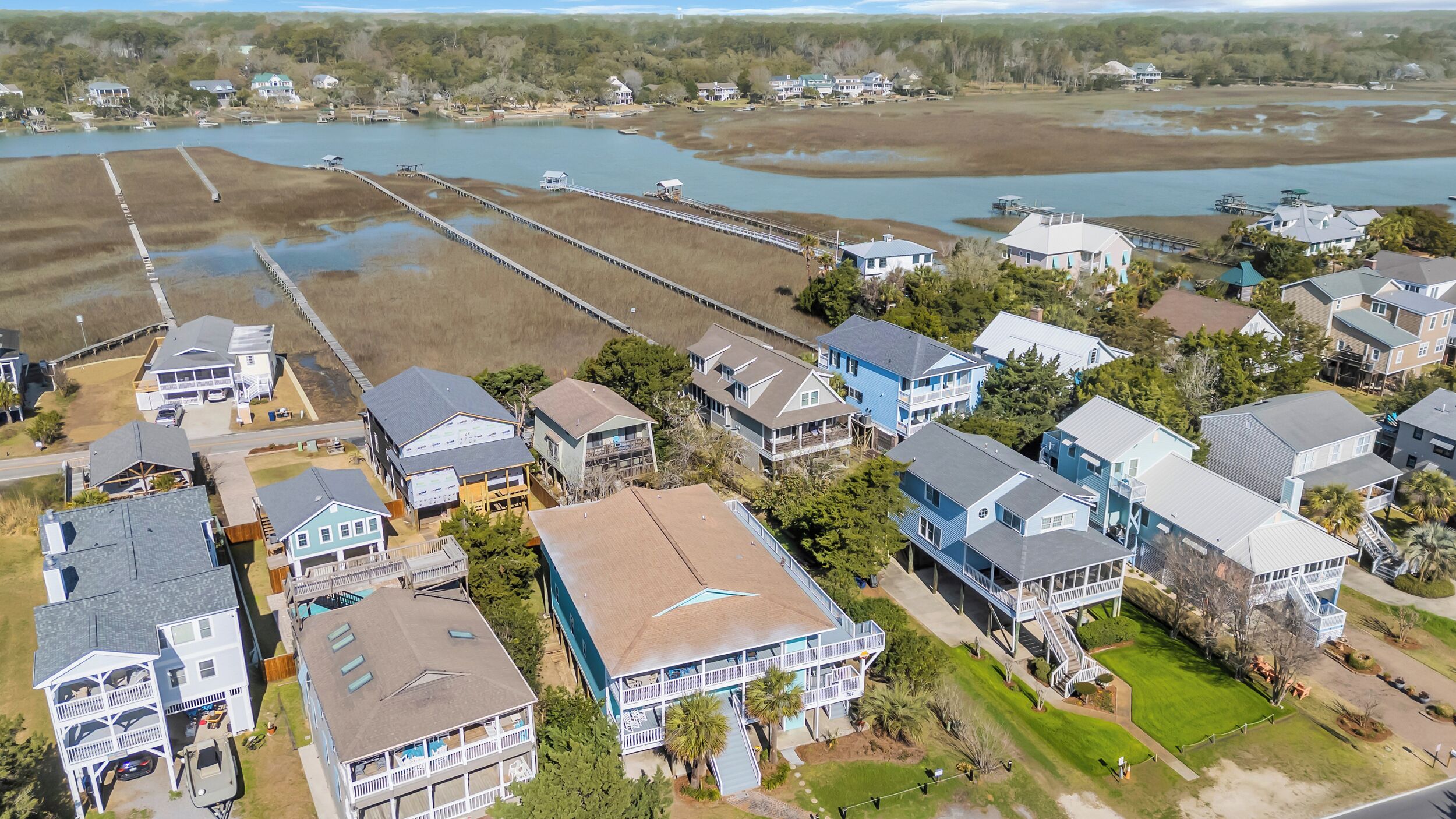Una zona residencial costera con casas, un muelle y una extensa masa de agua.