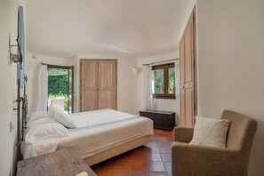 A bedroom with a bed, a chair, a wardrobe, and a window. - Villa Abbaiola - Porto Cervo Marina (Porto Cervo)
