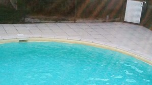 En swimmingpool med klart vatten och två metallstegar vid kanten.