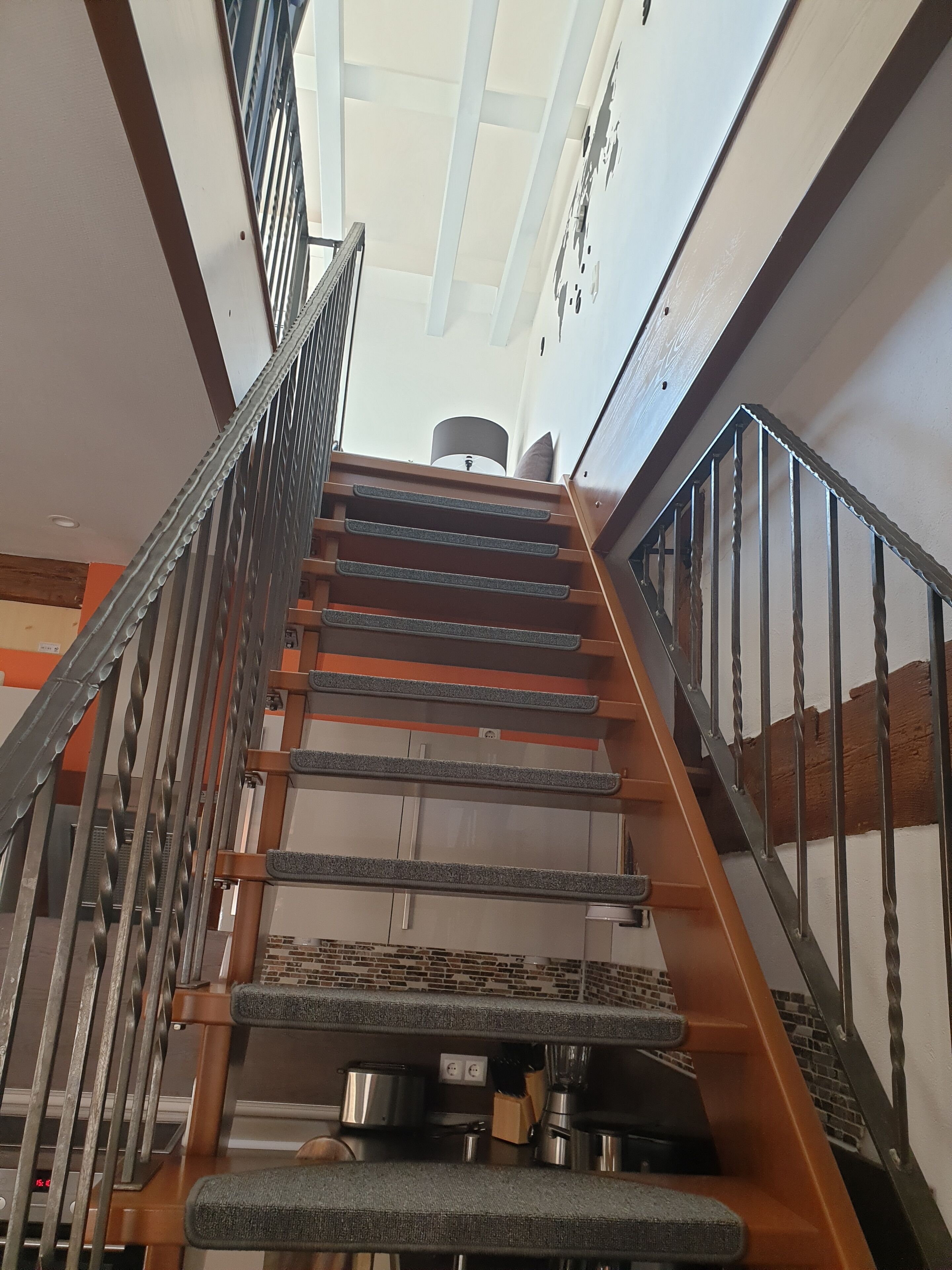 A staircase with metal railings and a view of the upper floor.