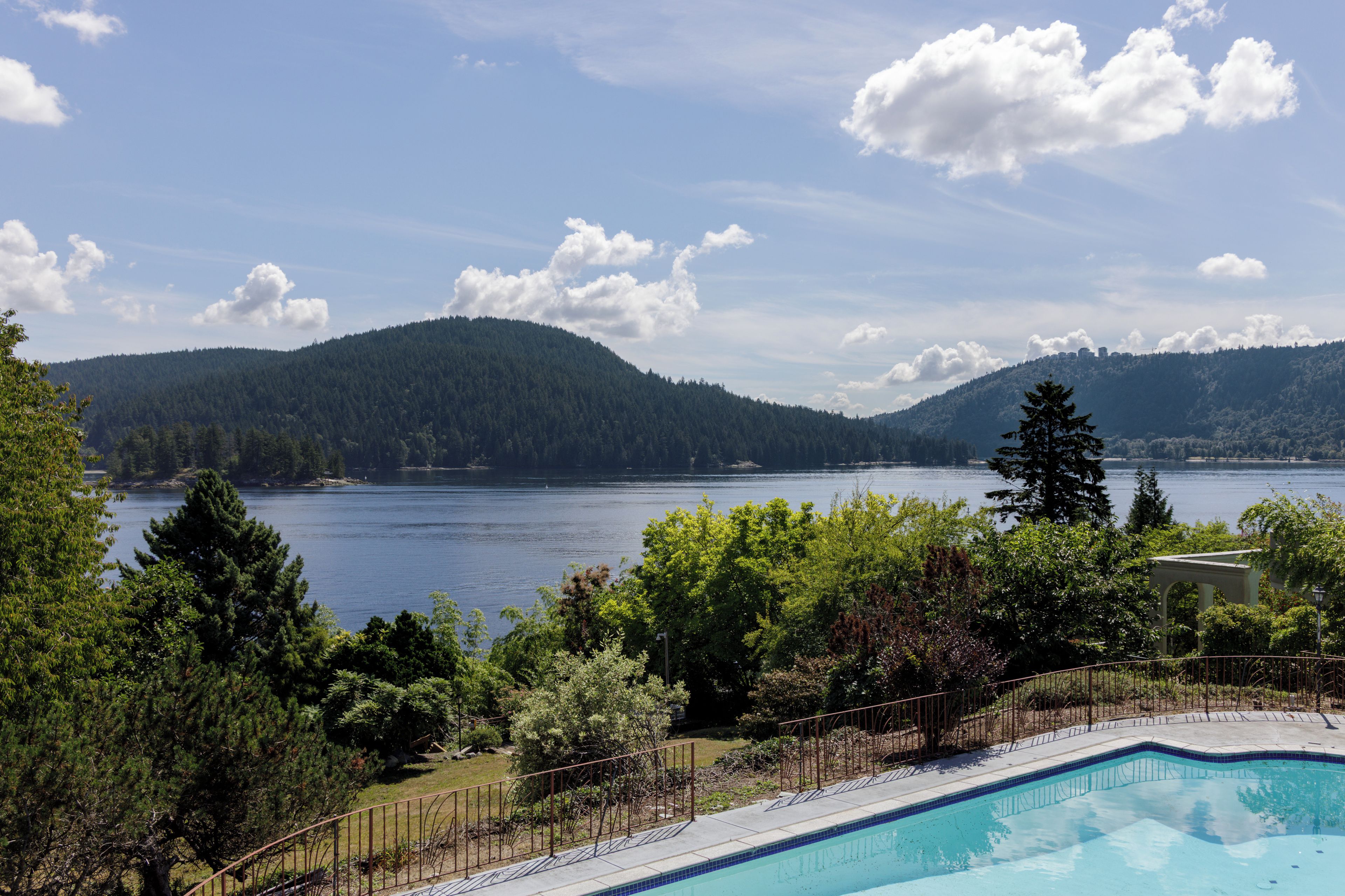 Una piscina con vistas a un lago y montañas.