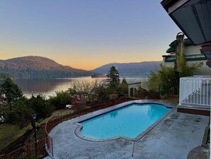 Piscina com vista para um lago e montanhas.