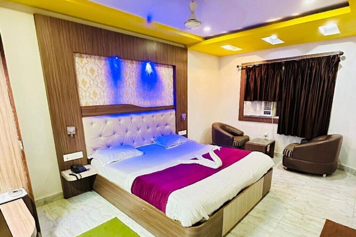 A modern hotel room with a large bed, a desk, and a chair.