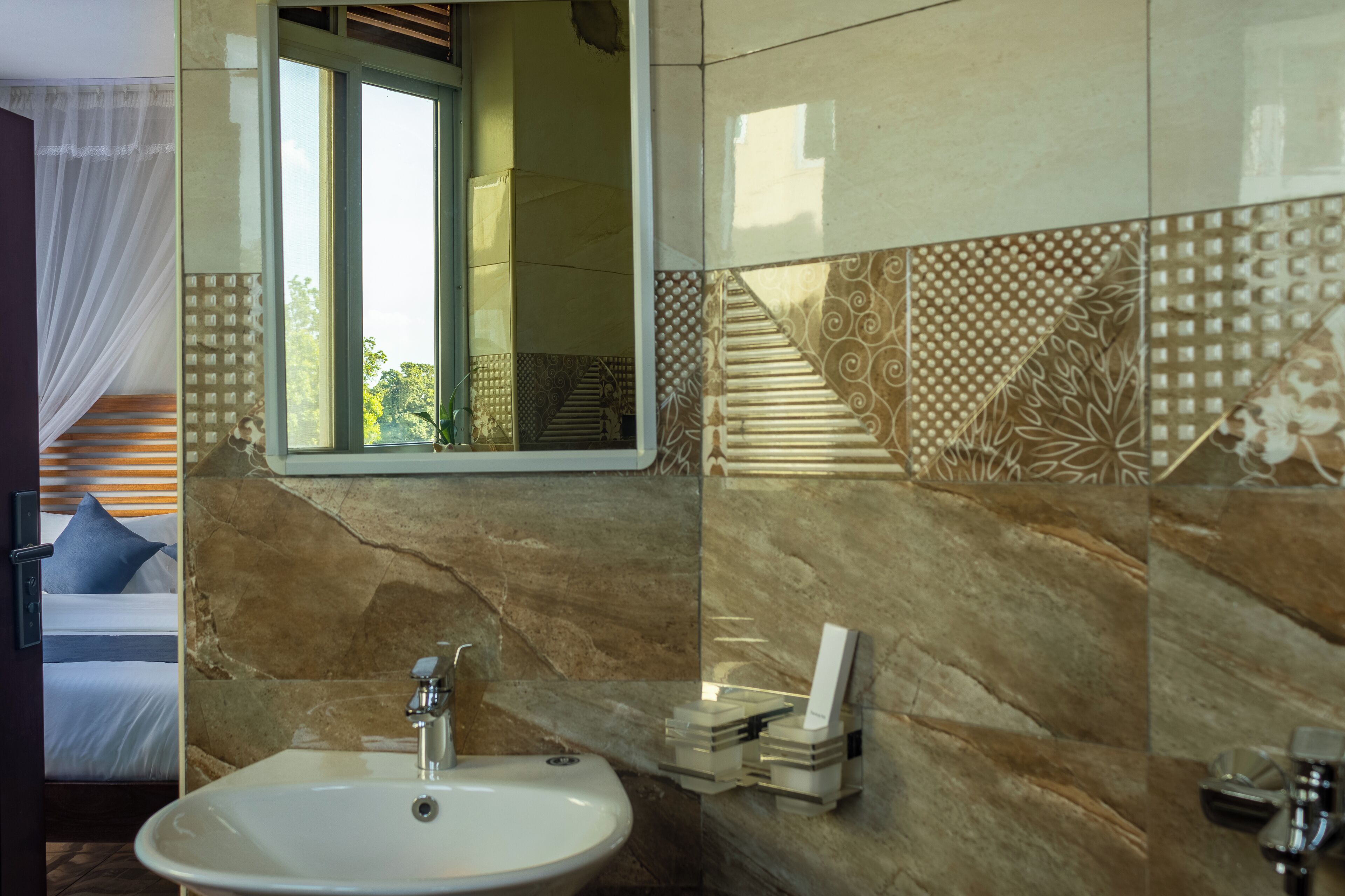 A bathroom with a marble sink, a mirror, and a towel rack.