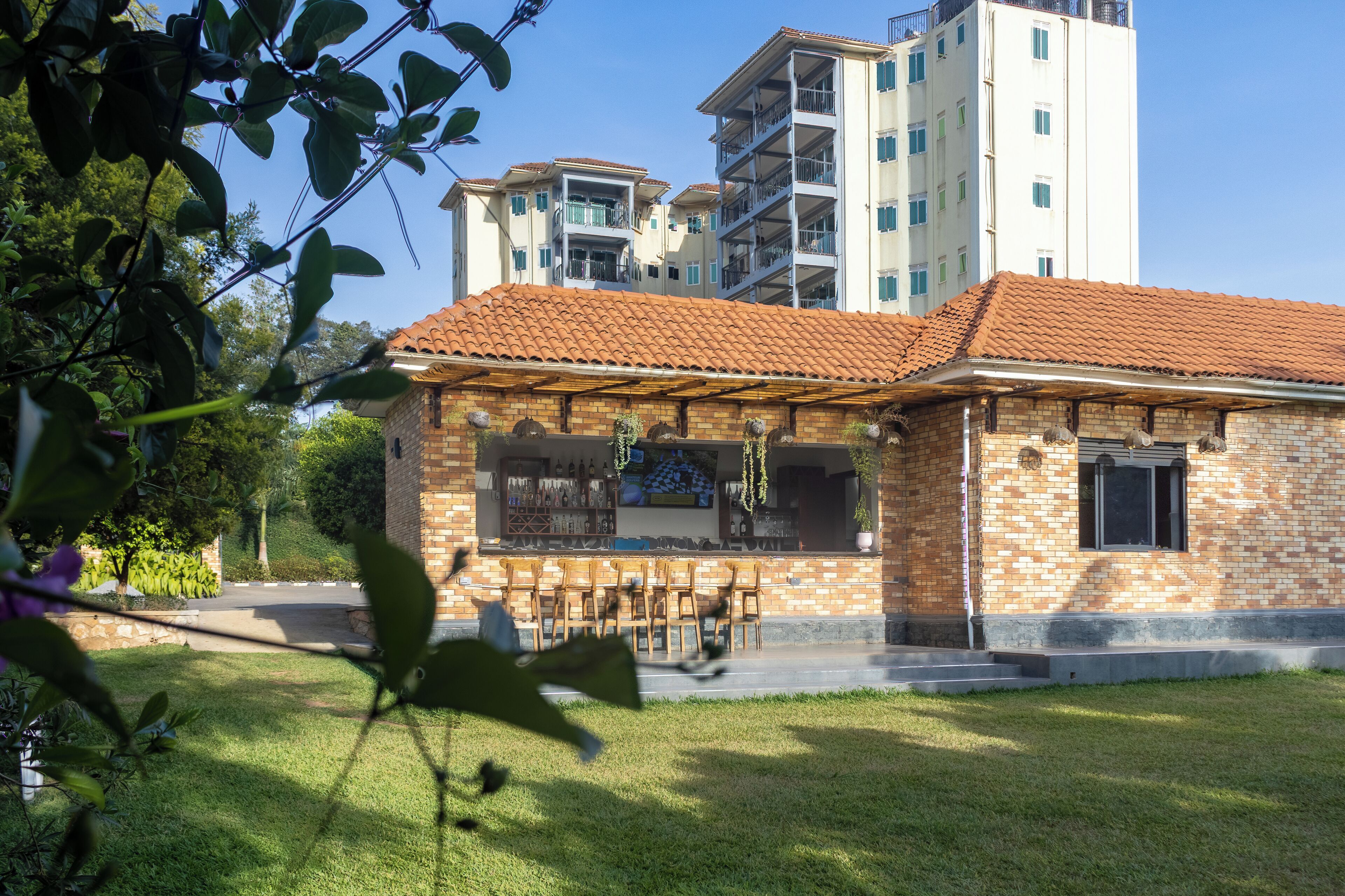 Ein Gebäude mit Ziegelverkleidung, einem Ziegeldach und einer kleinen Außen-Sitzgelegenheit mit Stühlen.