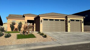 A two-story house with a garage, a driveway, and a well-maintained lawn.
