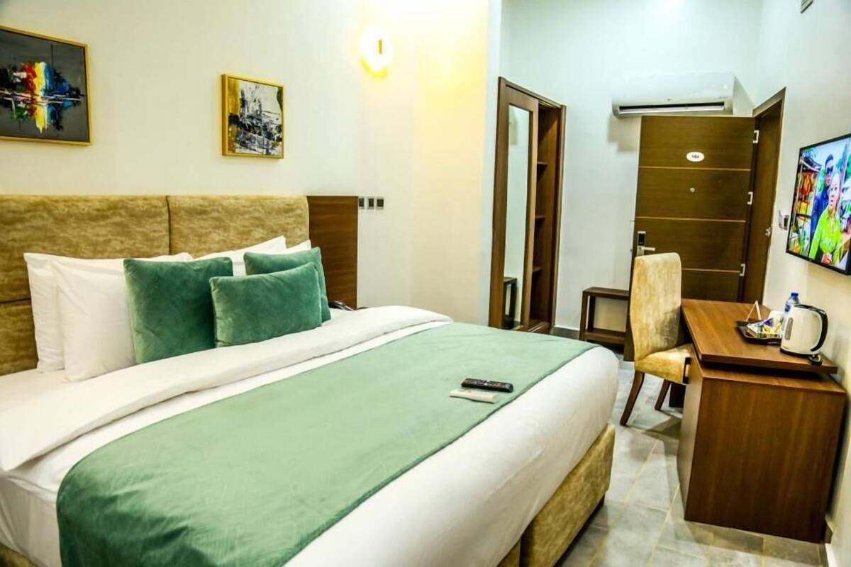 Une chambre d’hôtel équipée d’un lit, d’un bureau, d’une chaise, d’une télévision et d’une armoire.