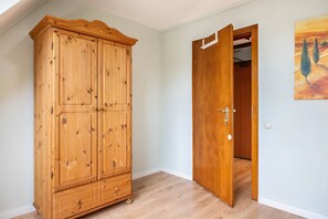 A room with a wooden wardrobe and a door leading to another room. - Apartment 'Enstipp' with Balcony and Wi-Fi (Krempermoor)