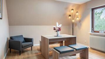 Ein modernes Wohnzimmer mit einer Couch, einem Holztisch mit Blumenvase und einer Bank.
