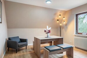 Una sala de estar moderna con un sofá, una mesa de centro de madera con un florero y un banco.