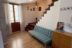 A room with a wooden staircase, a blue sofa, and a wooden cabinet. - Loggia Rialto Apartments - Ponte di Pietra (Venezia)