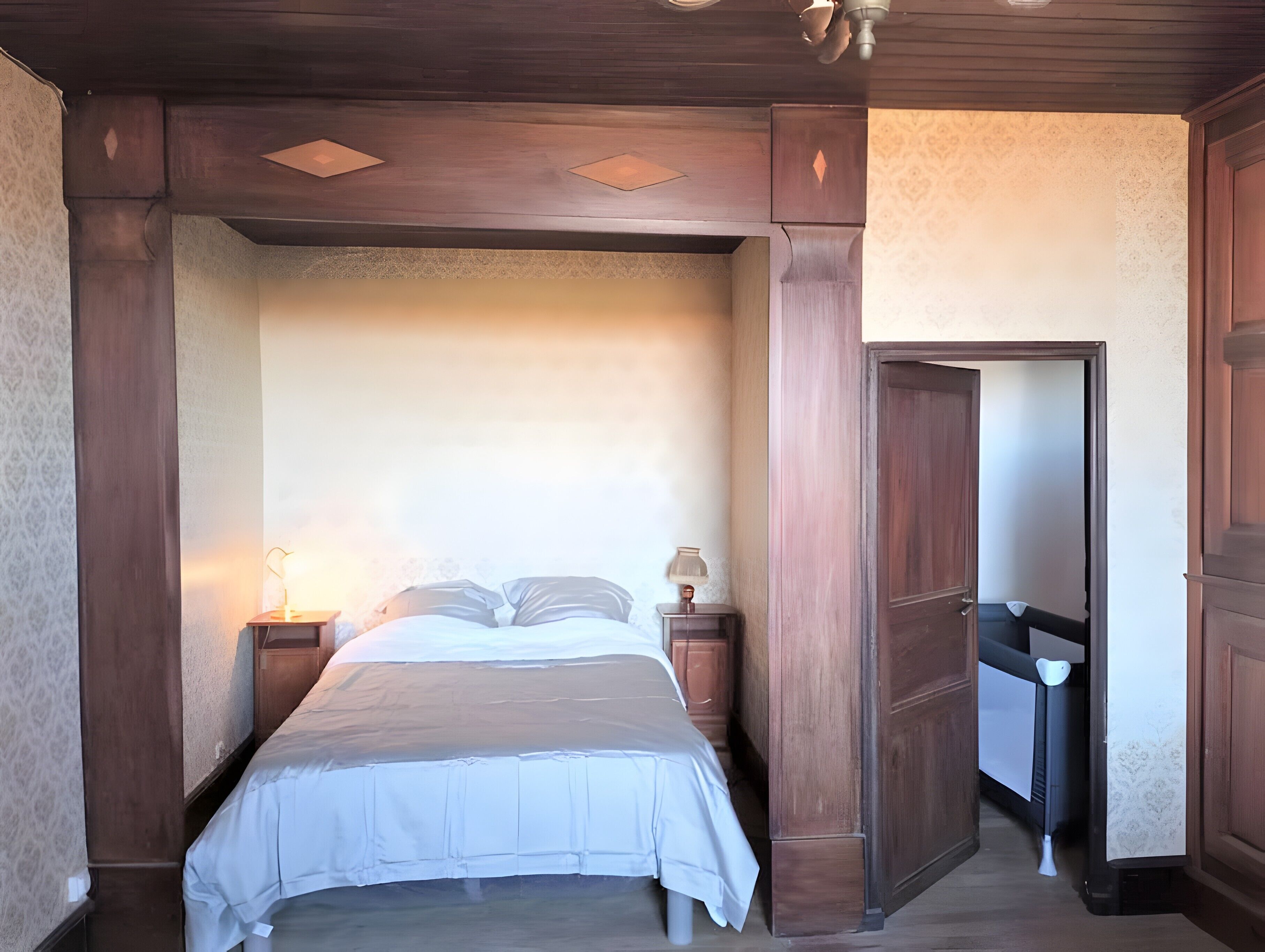 A bedroom with a bed, nightstands, and a wardrobe.