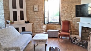 Une pièce confortable avec une cheminée, une télévision, un canapé et une table.