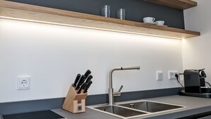 Eine moderne Küche mit integriertem Spülbecken, einer Kaffeemaschine und einem Messerblock.